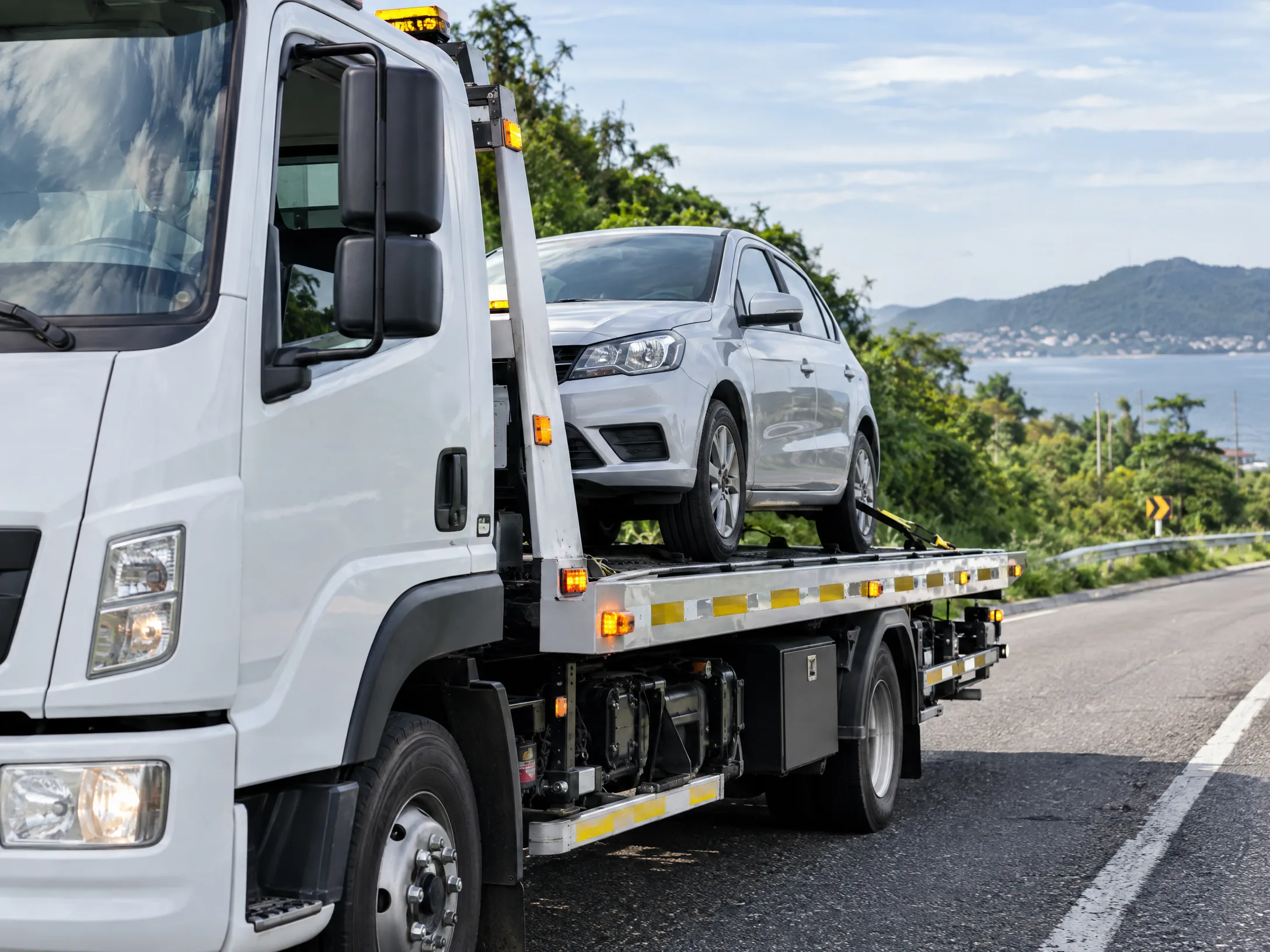 Caminhão plataforma realizando atendimento de guincho com segurança na estrada